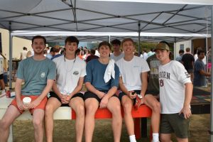 Brothers on bench under a tent wrapping up a success War of the Roses week.